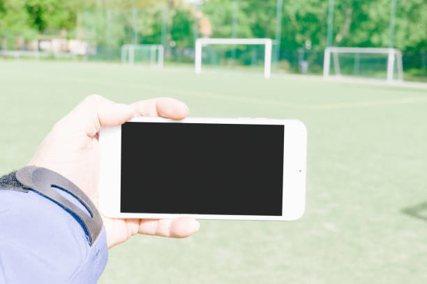 istock Cropped Hand Holding Mobile Phone Over Field 1036252470