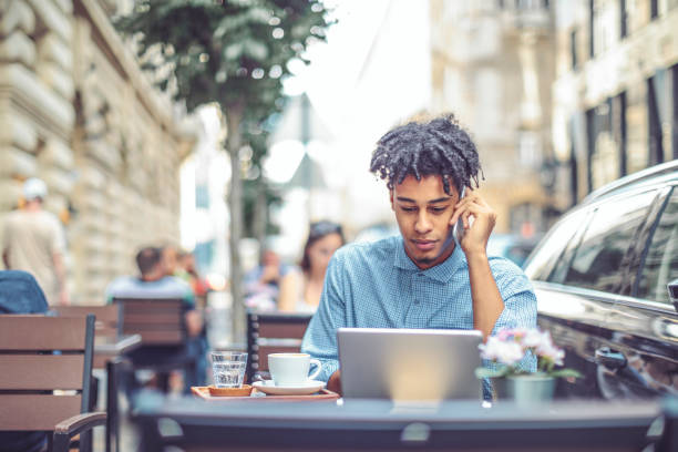 istock Young man is blogging from a sidewalk caffee 1036253816