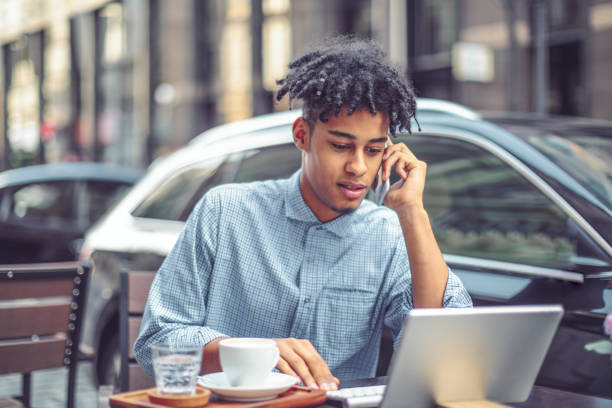 istock Young man is blogging from a sidewalk caffee 1036256200