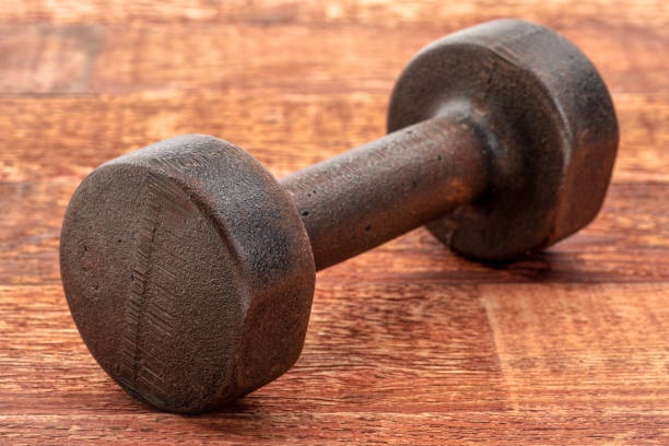 istock vintage iron dumbbell on wood 1036256702