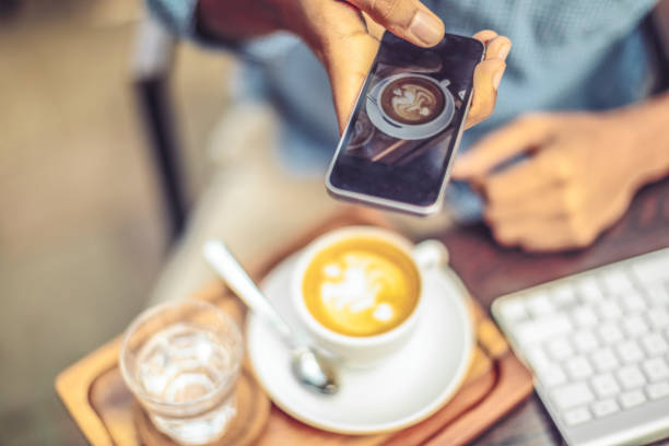 woman's hands holding smart phone and cup of coffee