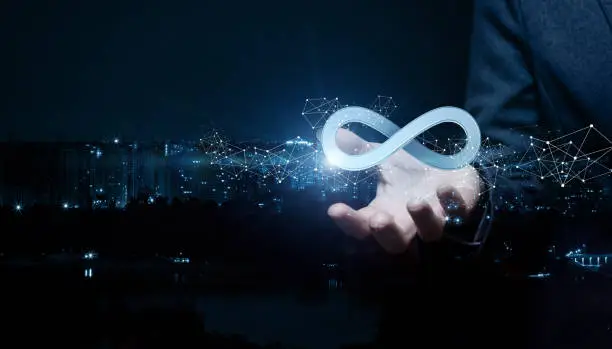 Businesswoman shows sign of infinity on the background of the city. The concept of unlimited Internet.