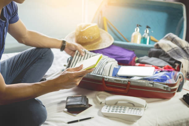 istock Midsection Of Man Checking To-Do-List While Packing Bag On Bed At Home 1036260620