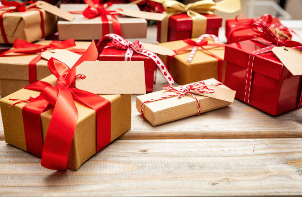 istock Christmas gift boxes with blank tags on wooden background, copy space 1036264910