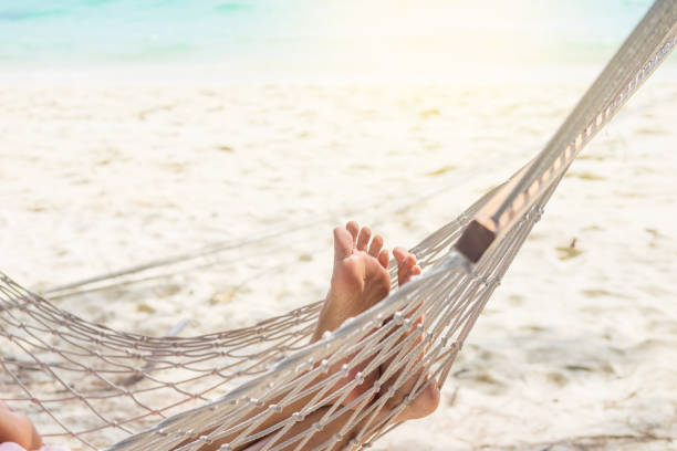 istock Low Section Of Person Relaxing On Hammock At Beach 1036265386