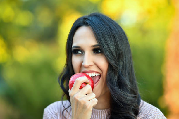 istock young woman eating an apple 1036267836