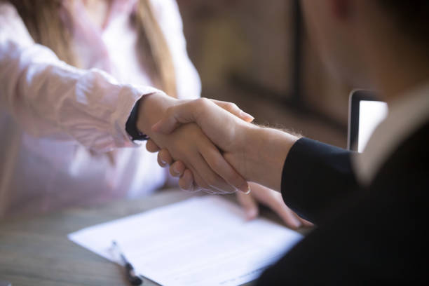 Handshake of man and woman Close up handshake of two successful businesspeople after good deal, broker and client shaking hands after sales negotiations, greeting, signing contract, HR concept bridging the gap stock pictures, royalty-free photos & images