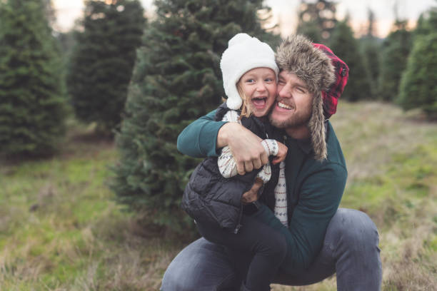 istock Dad playfully poses with his young daughter at a Christmas tree farm 1036275624