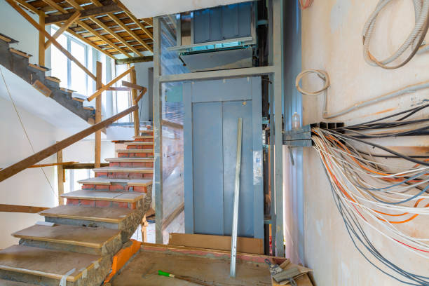 wall  with wires, stairs with temporary wooden railing and elevator in an apartment is during on the construction, remodeling, rebuilding and renovation. - restoring office built structure elevator imagens e fotografias de stock