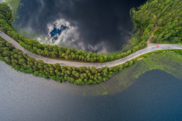 istock Road on a narrow piece of land between two lakes with forest 1036281454