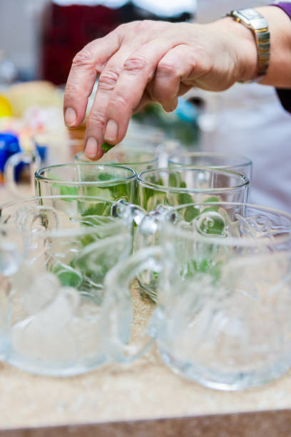Female Hand Making Mint Tea in Glass Tea Cups