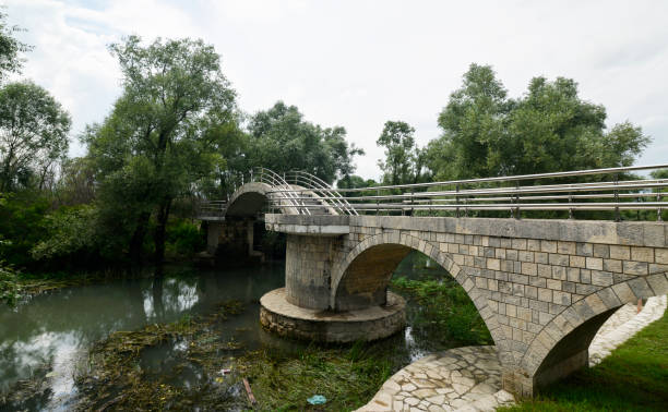 istock Modern stone bridge with a metal fence in the park 1036296578