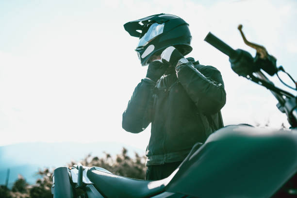 motorradfahrer mit spezialausrüstung getting ready to ride - sturzhelm stock-fotos und bilder