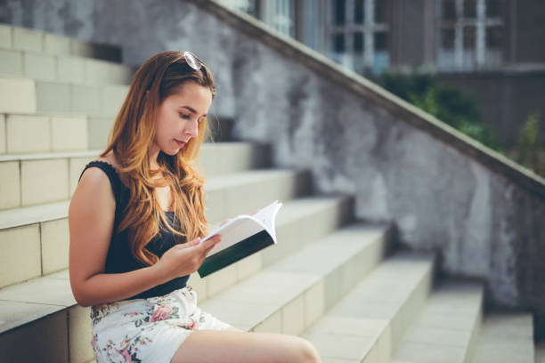 istock woman student reading book downtown 1036325334