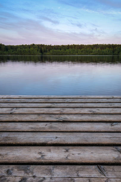 molo di legno sul lago sullo sfondo della foresta. la mattina presto. cornice verticale. - tranquil scene colors flowing water relaxation foto e immagini stock