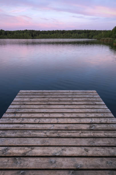 jetée en bois au bord du lac sur le fond de la forêt. tôt le matin. l’armature verticale. - reflection tranquil scene photography blue photos et images de collection