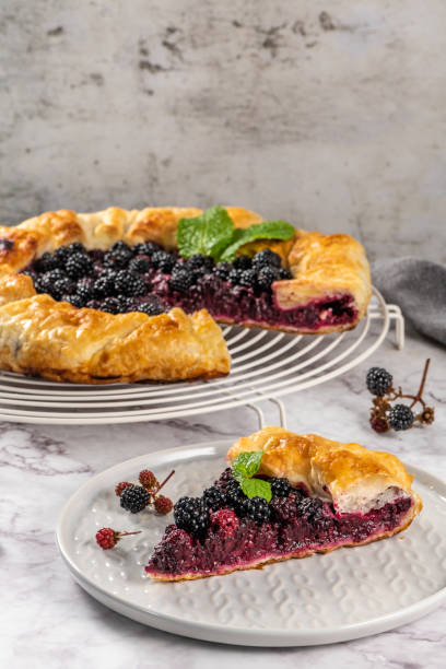 istock Blackberries pie with a slice on plate. Pie in summer with fresh picked wild blackberries. 1036327998