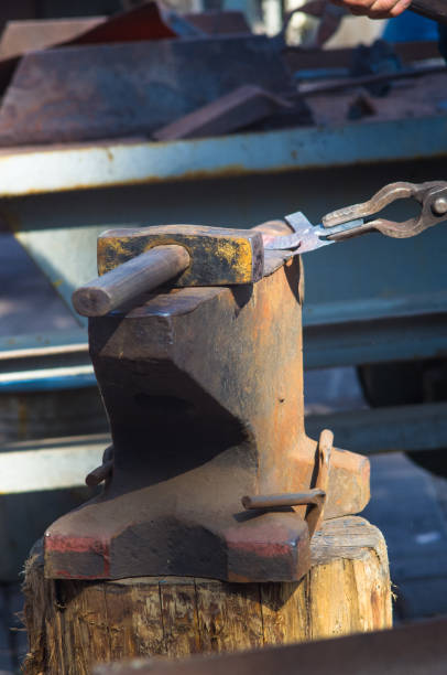 istock blacksmith performs the forging of hot glowing metal on the anvil 1036333582
