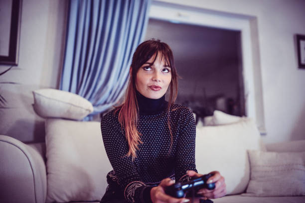 istock Excited Smiling Young Female Playing Video Game at Home 1036335800