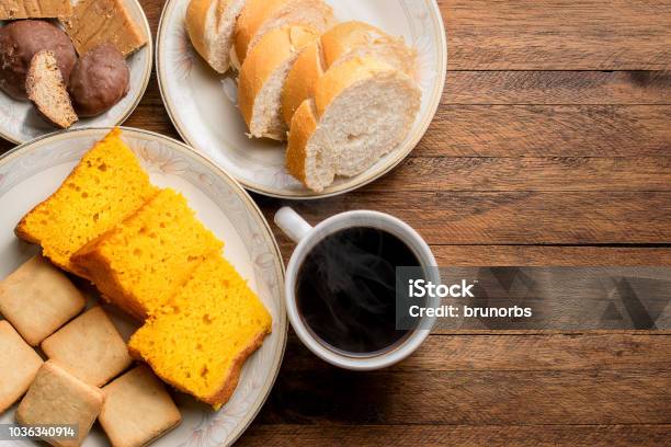 Photo libre de droit de Aliments Du Petit Déjeuner Sur Une Table En Bois Gâteau Aux Carottes Pain Biscuits Et Un Café Chaud Avec De La Vapeur Qui Sort banque d'images et plus d'images libres de droit de Petit déjeuner