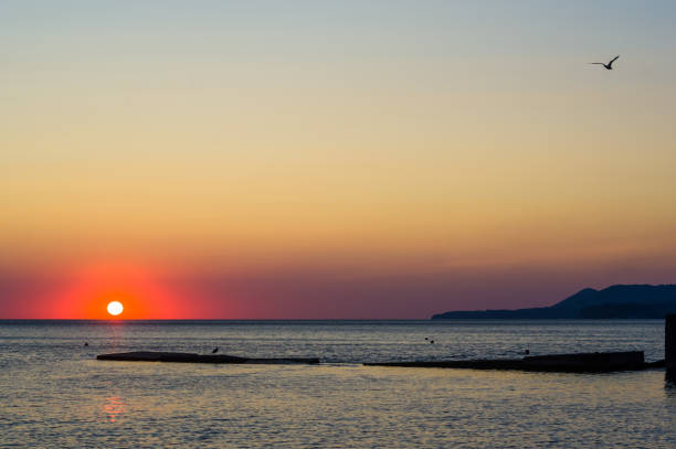 istock Amazing sea sunset on the pebble beach, the sun, waves, clouds 1036349486