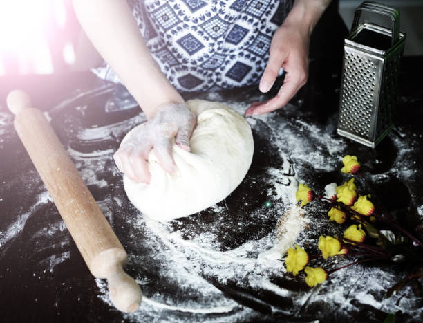 Close up of female baker hands kneading dough
