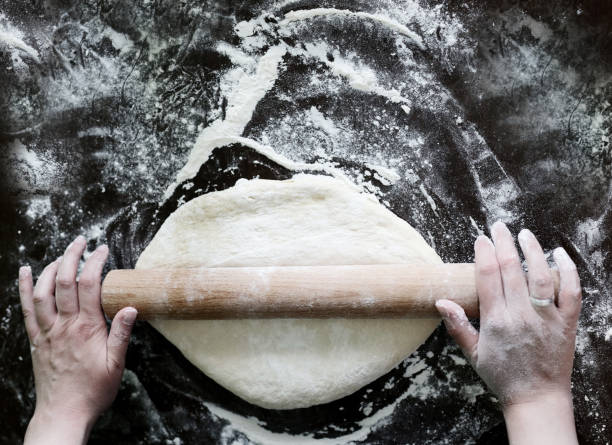 istock Close up of female baker hands kneading dough 1036353984