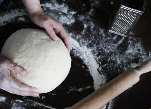 istock Close up of female baker hands kneading dough 1036354920