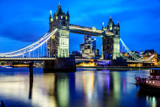 słynny tower bridge wieczorem z błękitnym niebem i odruchem na wodzie, londyn, anglia - london england thames river sky tower zdjęcia i obrazy z banku zdjęć