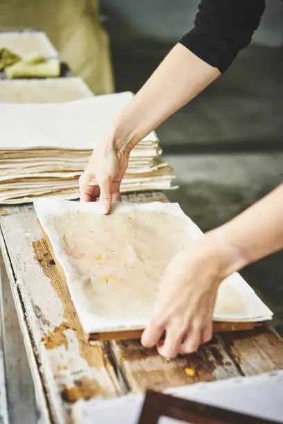 Preparing the paper to dry using blotting paper, featuring hands.