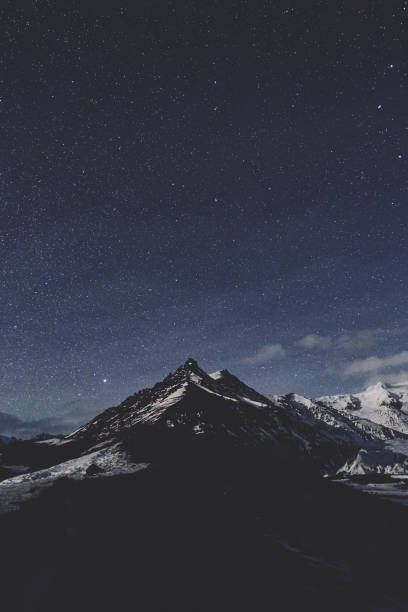 istock Mountain peak with snow and stars 1036370148
