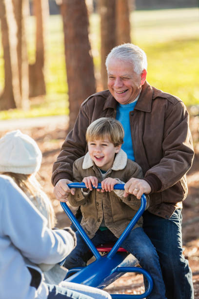 istock Boy with grandfather on seesaw at playground 1036389030