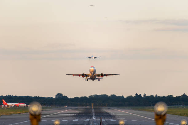 GATWICK AIRPORT, ENGLAND, UK – SEPTEMBER 13 2018: View directly down the runway as an easyJet Airlines plane takes off from Gatwick Airport GATWICK AIRPORT, ENGLAND, UK – SEPTEMBER 13 2018: View directly down the runway as an easyJet Airlines plane takes off from Gatwick Airport with planes coming in to land behind it in the background. airplane landing stock pictures, royalty-free photos & images