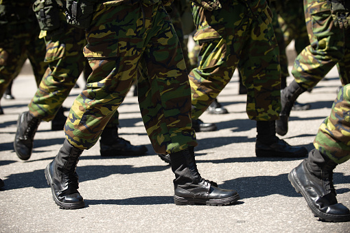 Militar en una calle. Piernas y zapatos en línea photo