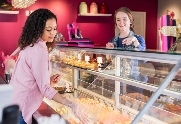 istock Young woman in pastry shop helping customer 1036476578