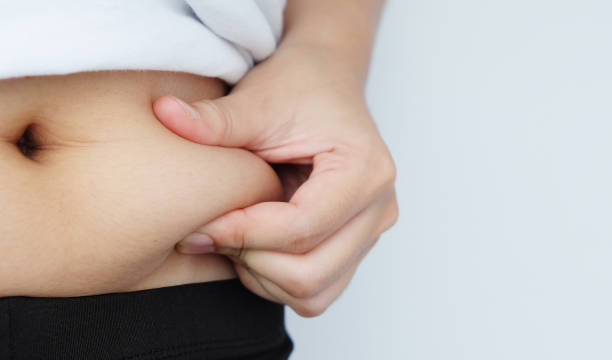 istock Side of woman hand catching fat body belly paunch , diabetic risk factor 1036483726