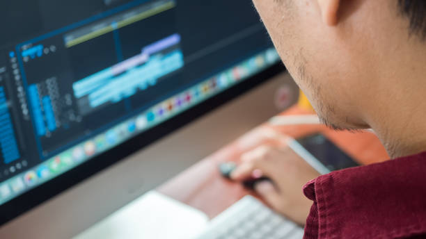 istock Male Videographer Edits and Cuts Footage and Sound on His Personal Computer.Shift focus 1036529330