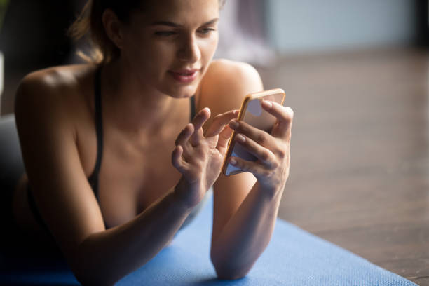 istock Young sporty woman holding phone and using app 1036550498