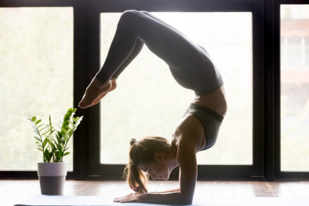 istock Young sporty woman doing yoga Scorpion backbend pose 1036550500