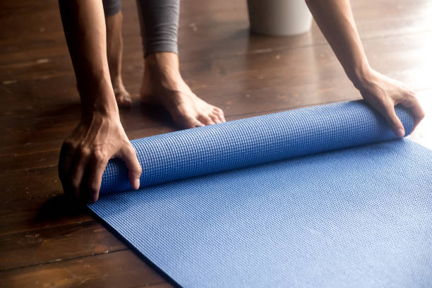 istock Time for practice, female hands unrolling blue yoga mat 1036550622