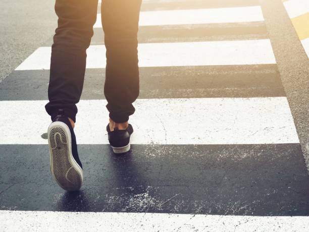 cierre hasta pies caminando paso peatonal de seguridad en carretera, seguridad calzada firma símbolo - pedestrian fotografías e imágenes de stock