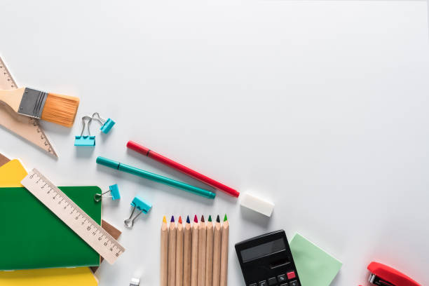 istock Top view over a notebooks, paints, pencils, rulers, paper clips, brushes, stepler, glue, sharpener, pens, paper on a white background. Back to school concept. Office supplies flat lay 1036558562