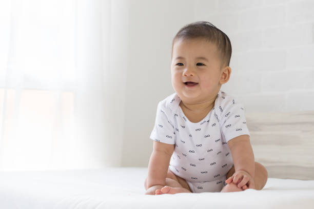 istock Baby boy smiling on white bed in the bedroom 1036563048