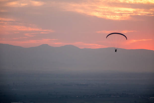 istock Paraglider soaring over  mountains with a beautiful scenery  in sunset 1036563320