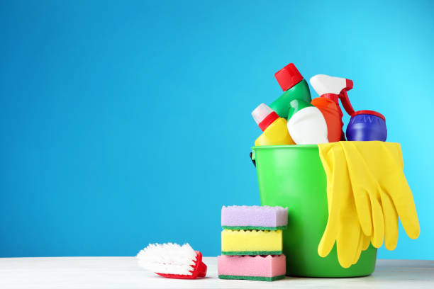 istock Bottles with detergent and cleaning tools on blue background 1036570634