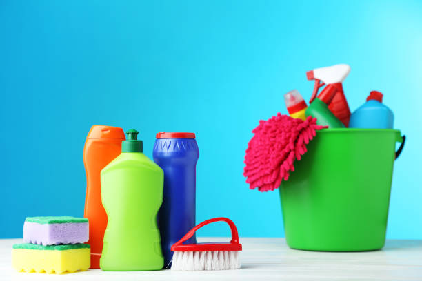 istock Bottles with detergent and cleaning tools on blue background 1036574396