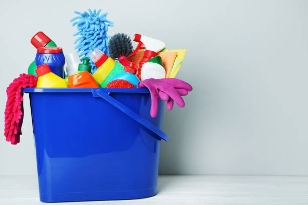 istock Bottles with detergent and cleaning tools on gray background 1036574584
