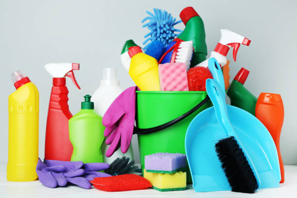 istock Bottles with detergent and cleaning tools on gray background 1036577738
