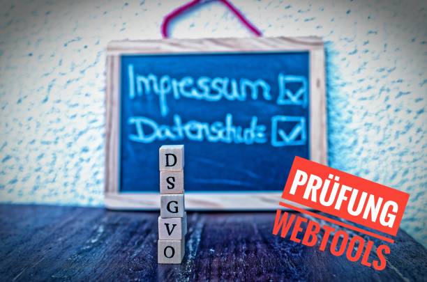 Building Blocks with the inscription DSGVO (General Data Protection Regulation) in English GDPR (General Data Protection Regulation) and a board with the inscription Imprint and Privacy and Testing Web Tools (in german Impressum Datenschutz und Prüfung Webtools) bloques de construcción con la inscripción dsgvo (reglamento general de protección de datos) en inglés gdpr (reglamento general de protección de datos) y un tablero con pie de imprenta y privacidad y herramientas de pruebas en alemán impressum datens