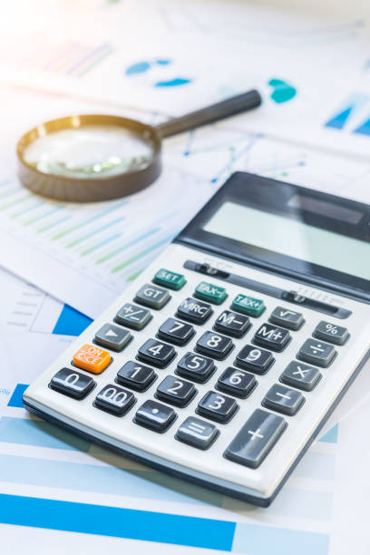 istock Calculator and Magnifying with Business Graphs finance document. 1036601268